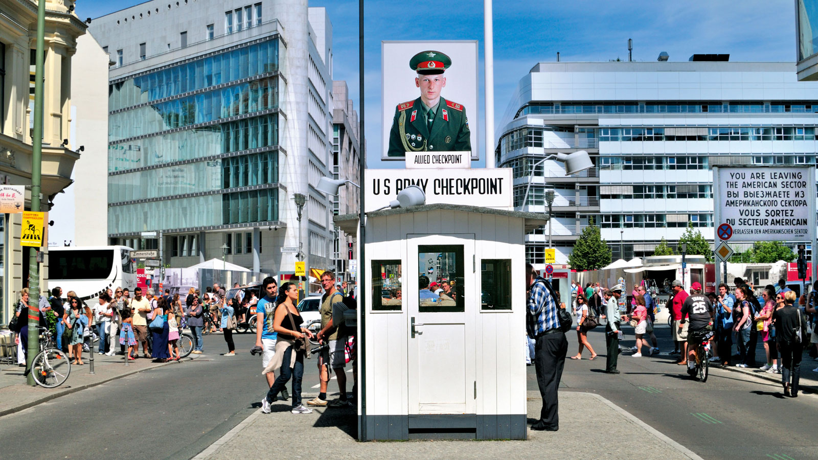 Blick auf das rekonstruierte Kontrollhäuschen des Checkpoint Charlie mit Fußgängern