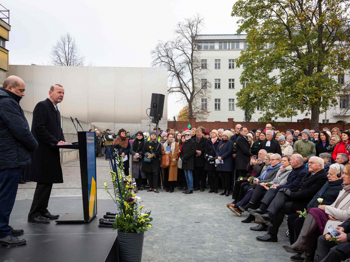 Zwei Personen stehen vor Publikum auf einer Bühne an der Gedenkstätte Berliner Mauer