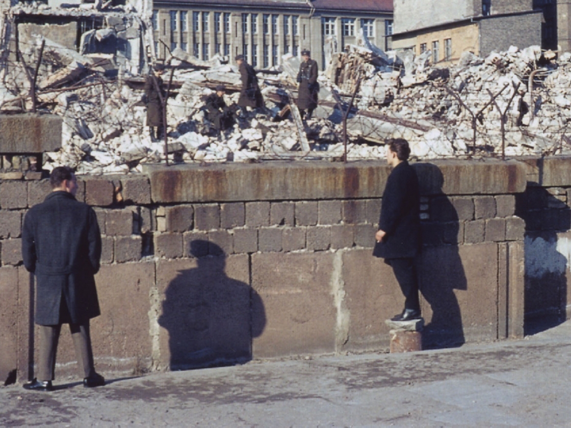 West-Berliner vis à vis mit Grenzsoldaten auf den Trümmern eines Grenzhauses 
