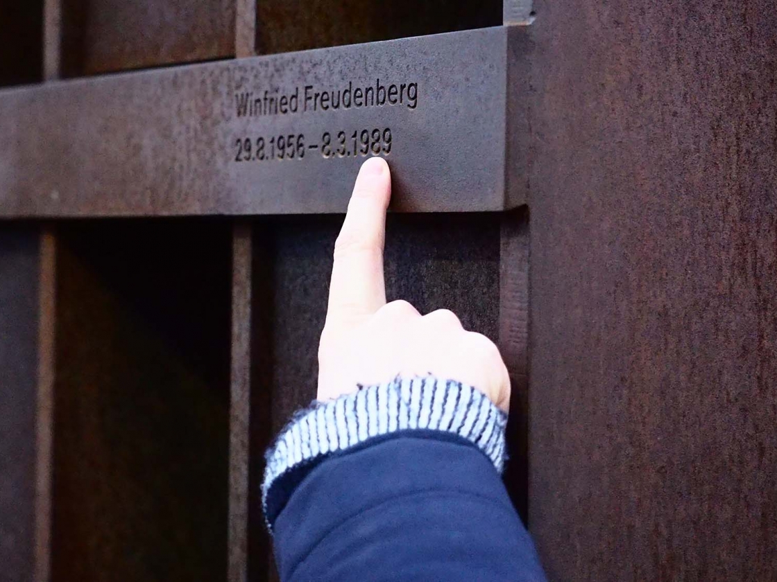 Eine Hand zeigt auf das Fenster des Gedenkens