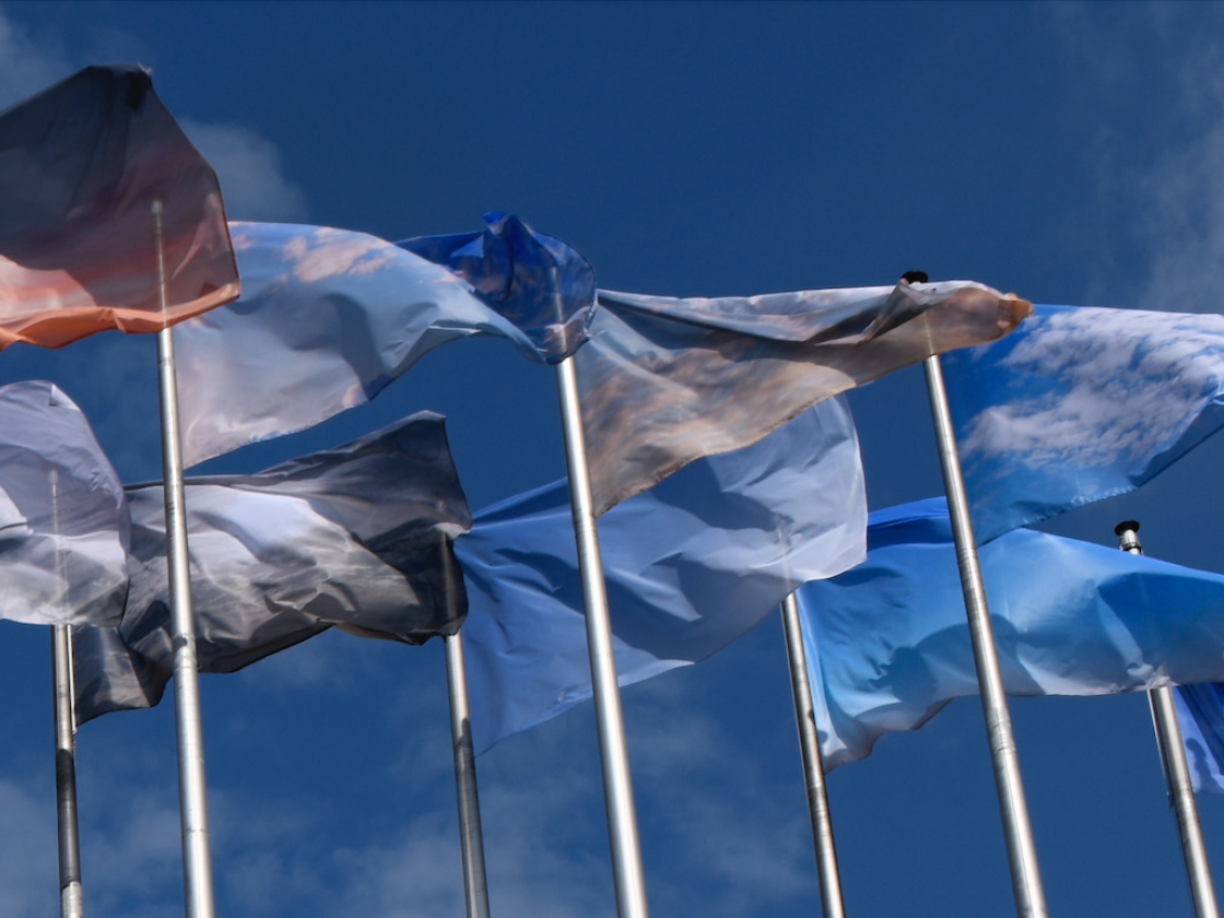 Wehende Fahnen, die mit Himmelsbildern bedruckt sind 